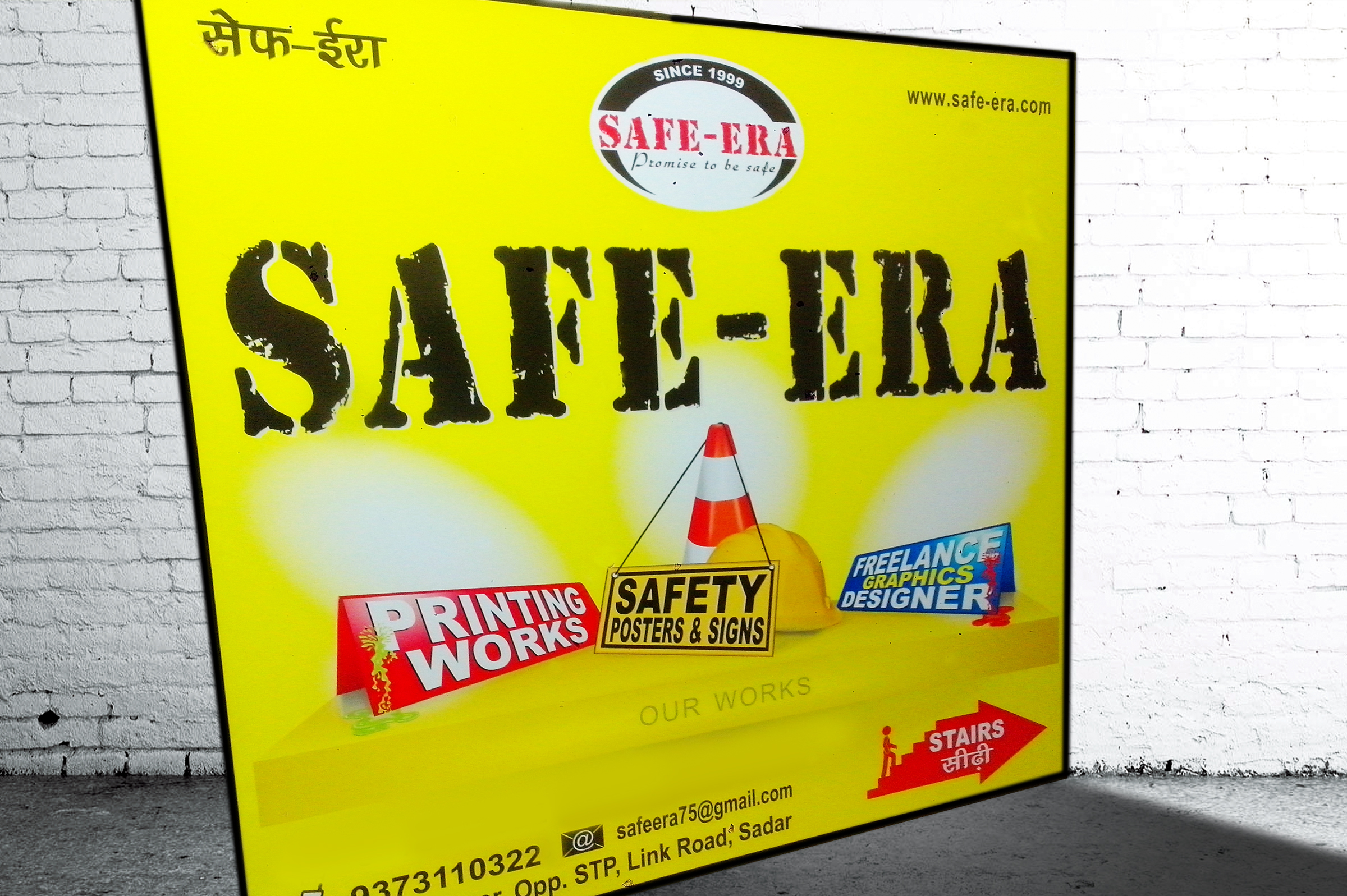 picture for safe-era company profile. picture showing white brick wall in the back, after that one flex board is kept with bright yellow plain background, design mentioned safe-era logo on the top center, safe-era logo with black half round with red color font, below that written safe-era in black color with capital letter with rubber stamp font, below that - from left one red name plate kept - printing work text on that, after that in center one traffic cone with yellow industrial helmet with yellow board kept near yellow helmet - text written safety posters & signs in black font, capital letter, bold. after that in right side of the board with blue colour table name plate with red colour paint splash on that name plate, text written - freelance graphics designer with white and yellow colour with bold font. under under that in center "our works" in capital font, below that extreme bottom of the board, in left side phone no. with mobile symbol no. written 9373110322 then email id symbol on black - text - safeera75@gmail.com, below that office address written in black colour - text - block no. c/42, 1st floor, opposite STP, link road, sadar. in right side of the bottom of the board symbol with right arrow with stairs on it and one carton person moving on the stairs,text wirtten - STAIRS in white colour with capital with hindi text under english text "sidhi", symbol is in red colour. board background is in bright yellow colour, on the right side of the board - website name written - www.safe-era.com, since 1999